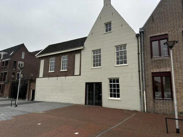 Voorgevel van een historisch gebouw aan het Sint-Agathaplein met gemetselde en wit gepleisterde gevels.
